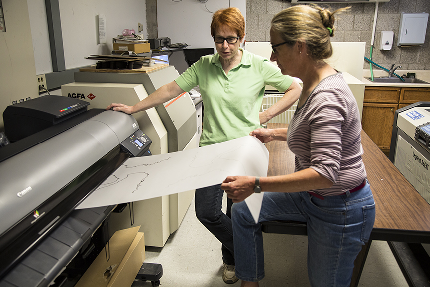 Roberley (right) and Kathrine Vajda printing out transparent overlays for Roberley's writings